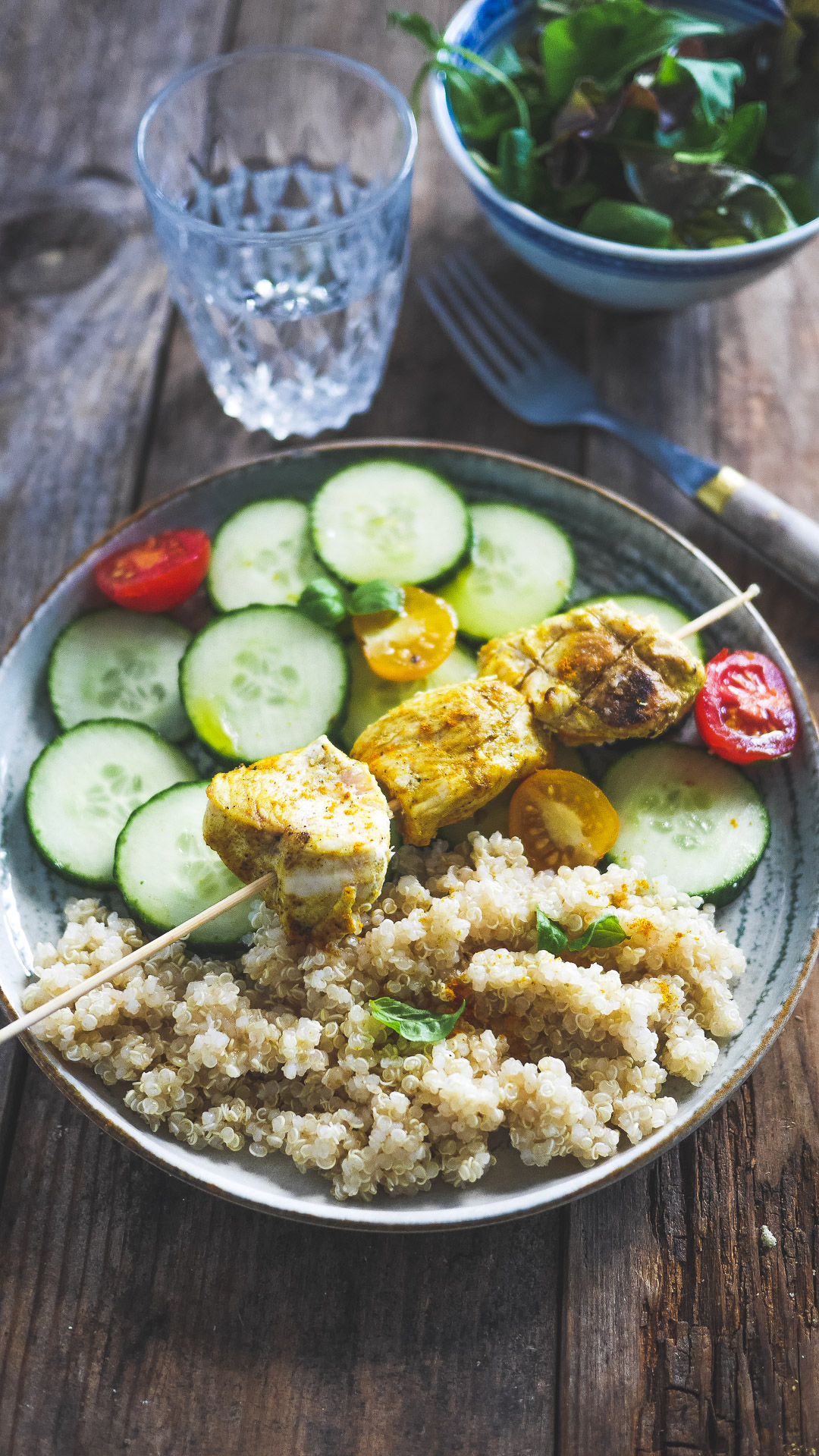 Brochette de poulet curry à l'airfryer servie sur une assiette de quinoa et concombre