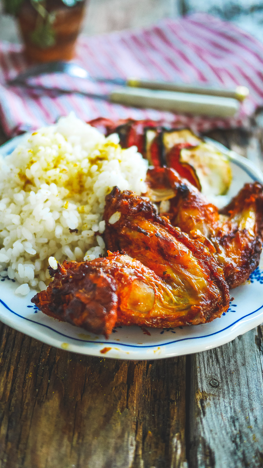 ailes de poulet tex mex cuites à l'airfryer, posées dans une assiette avec du tian de légumes et du riz