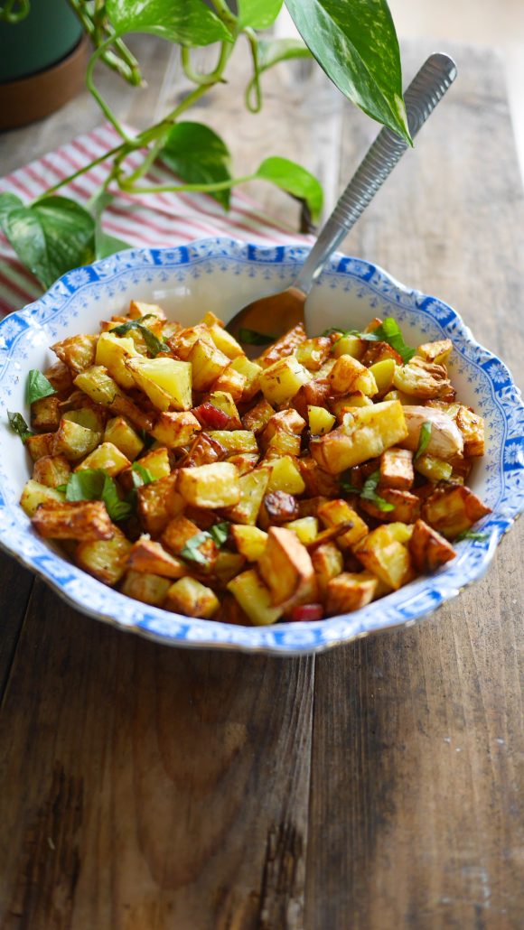 saladier de patates sautées aux lardons avec du basilic parsemé dessus